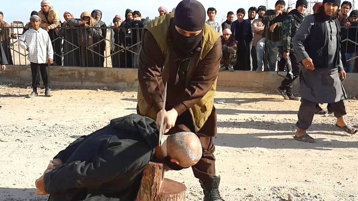 عنصر من تنظيم داعش الإرهابي ينفذ "حد" قطع الرأس
