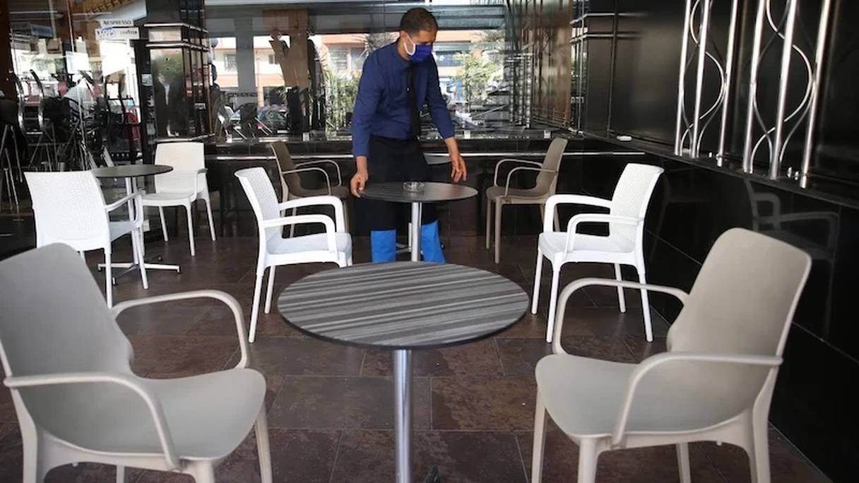 نادل يرتب مقاعد إحدى المقاهي بمدينة الدار البيضاء