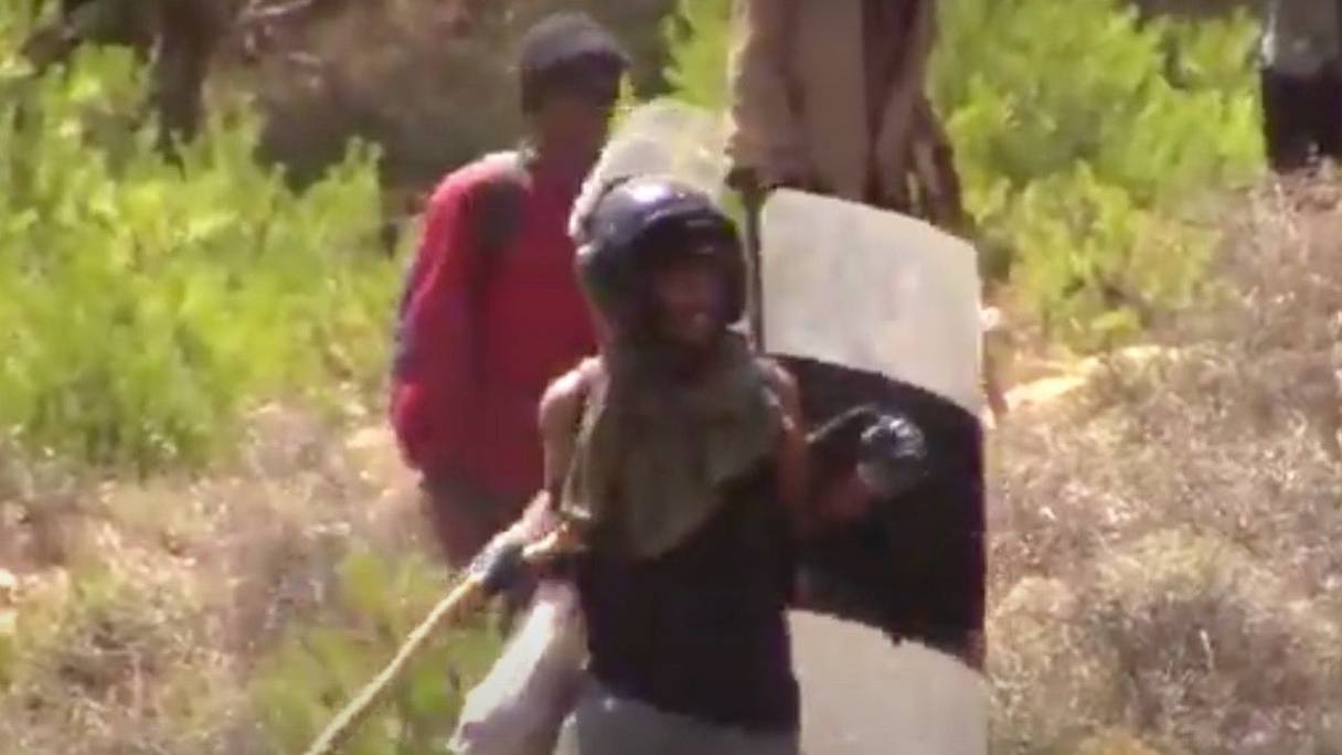أحد المهاجرين يظهر في الفيديو وهو يرمي بالحجارة على القوات العمومية بعد استيلاءه على خوذة ودرع الأمن
