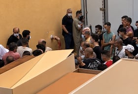 Des corps des victimes des feux de forêt en Algérie transportés à bord de camions réfrigérés destinés aux produits alimentaires.