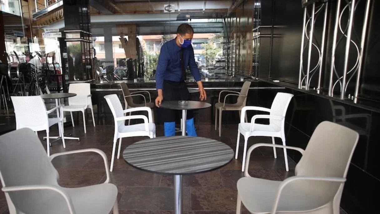 نادل يرتب مقاعد إحدى المقاهي بمدينة الدار البيضاء