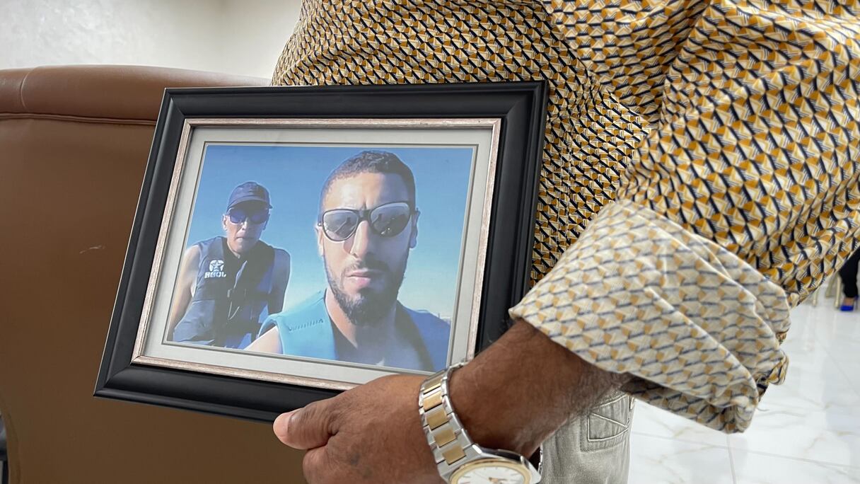 Mostafa Mchiouer portant le portrait de son fils Abdelali, le jeune marocain tué par la marine algérienne, lors d'une conférence de presse, mardi 26 septembre 2023 à Casablanca.
