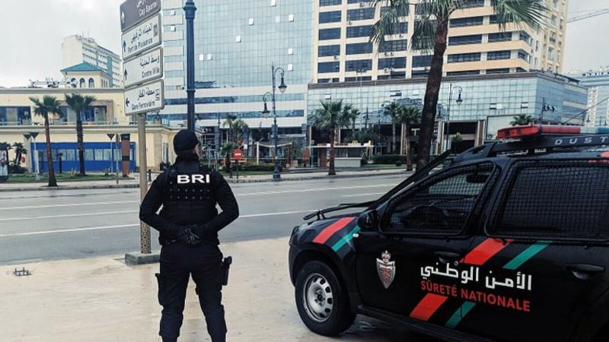 شرطي إلى جانب سيارة شرطة بمدينة طنجة