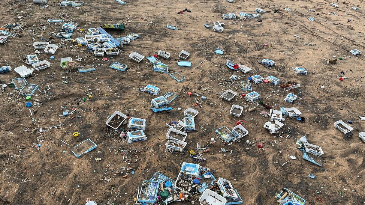 نفايات الحاويات الجانحة لسفينة «إيونيكوس» الليبيرية تلوث شاطئ عين الذئاب