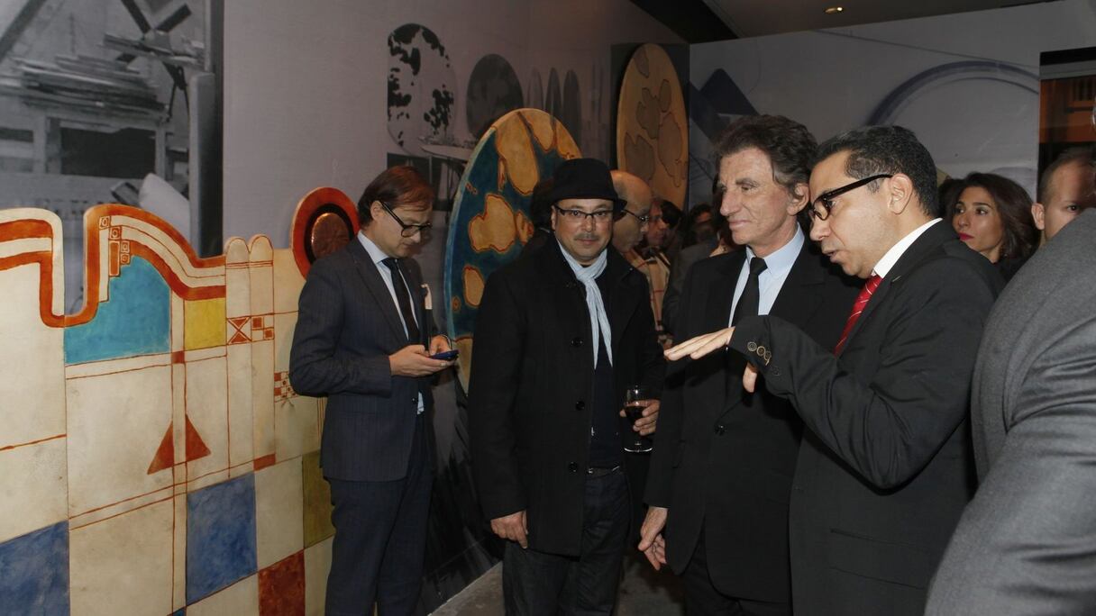 عزيز الداكي يقدم تفسيرات للوزير الفرنسي السابق حول بعض الأعمال المعروضة في الورشة.
