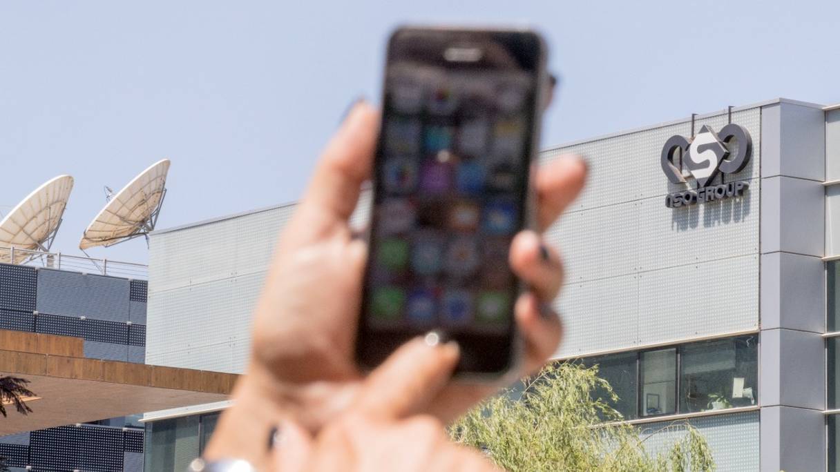 Une femme utilise son iPhone devant le bâtiment abritant le groupe israélien NSO, à Herzliya, près de Tel Aviv. L'entreprise israélienne est accusée d'avoir fourni le logiciel espion Pegasus à plusieurs Etats, dont le Maroc (photo d'archives, 2016).
