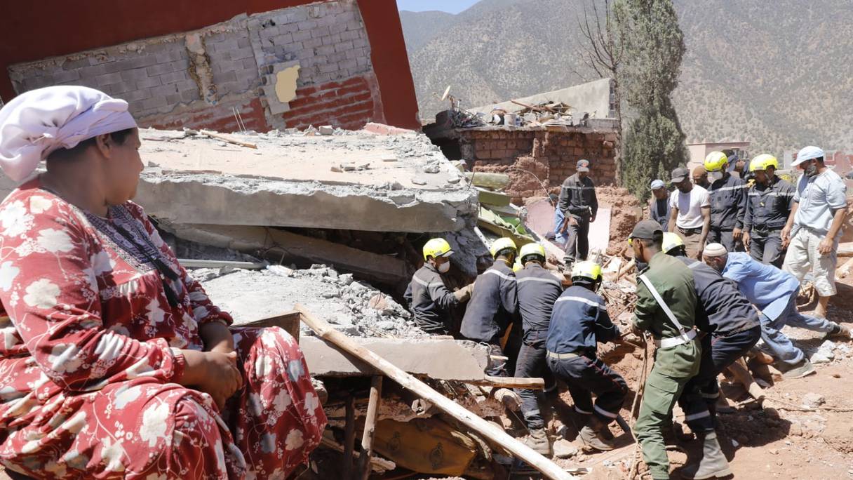 امرأة تتابع جهود عناصر السلطة المحلية أثناء عملية انتشال ضحايا زلزال الحوز